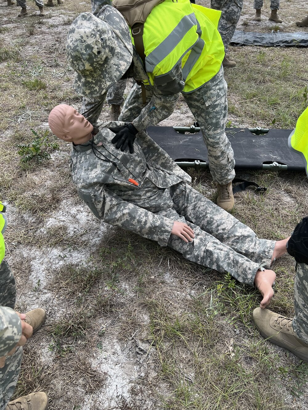 Devin Fred moving a training manikin onto a litter during a search and rescue drill