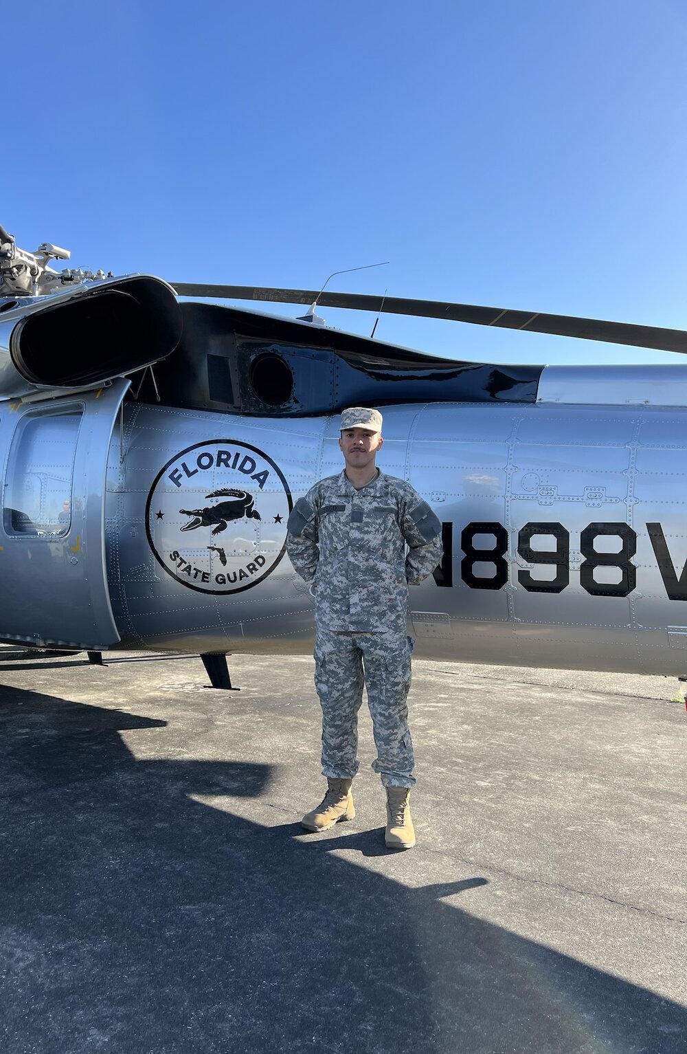 Devin Fred in Florida State Guard uniform beside a State Guard helicopter